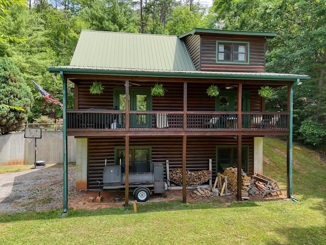 rear view of property featuring ceiling fan, a yard, and a wooden deck