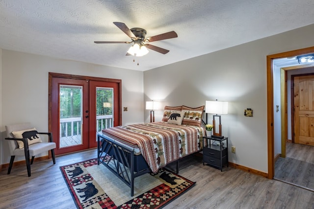 bedroom featuring baseboards, french doors, wood finished floors, and access to exterior