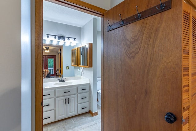 bathroom with a ceiling fan, vanity, toilet, and a textured ceiling