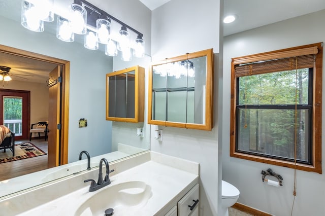 ensuite bathroom featuring toilet, plenty of natural light, a ceiling fan, and vanity