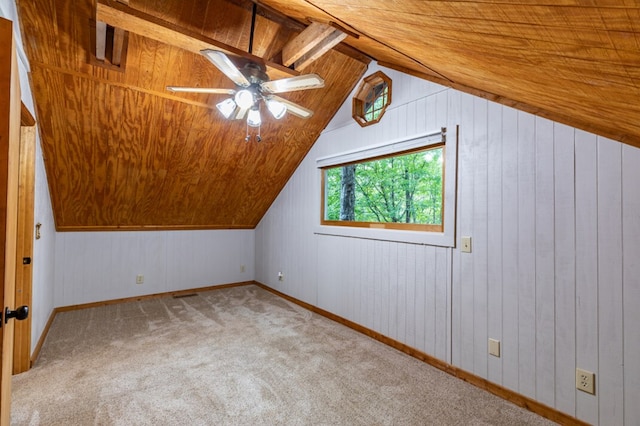 bonus room featuring wooden ceiling, wood walls, carpet flooring, a ceiling fan, and vaulted ceiling