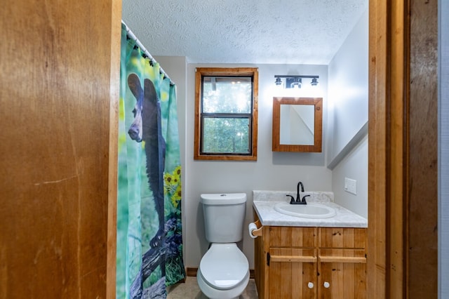 bathroom with a textured ceiling, curtained shower, vanity, and toilet