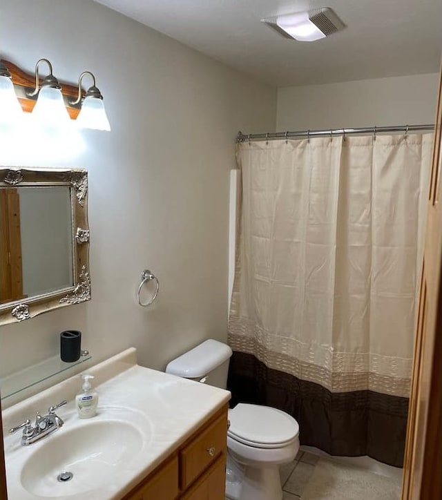 bathroom with tile patterned flooring, vanity, and toilet