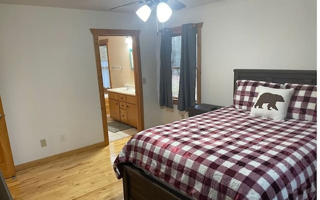 bedroom featuring ensuite bathroom, ceiling fan, and light wood-type flooring