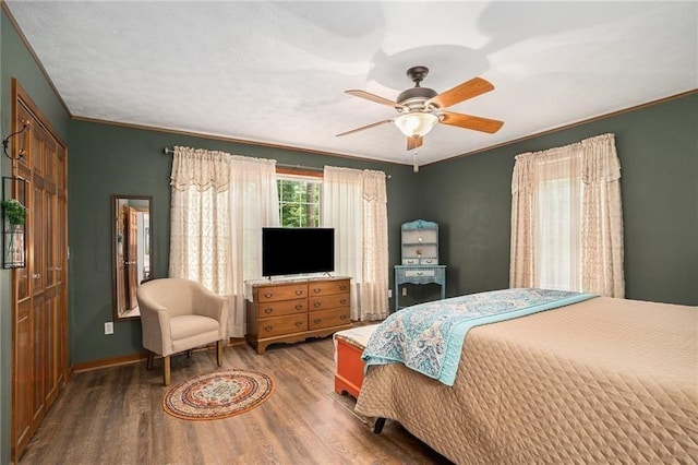 bedroom with ceiling fan, baseboards, wood finished floors, and ornamental molding