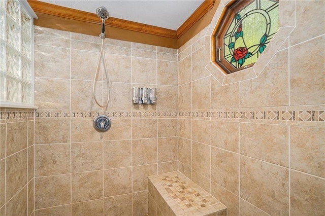 bathroom with crown molding and a tile shower