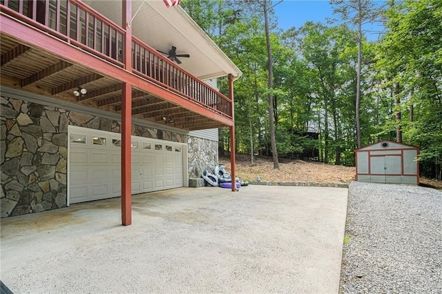 exterior space featuring an outbuilding, a ceiling fan, driveway, a storage unit, and stone siding