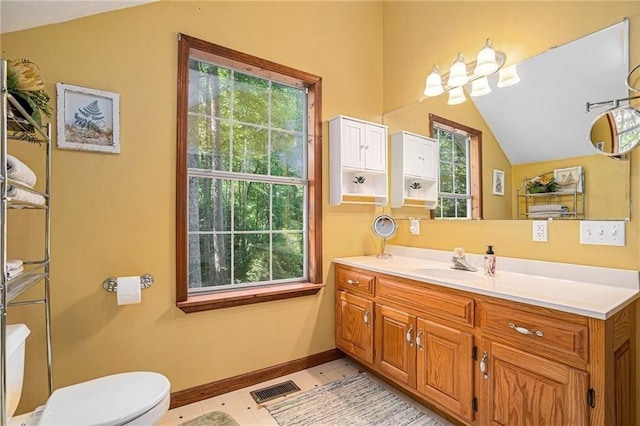 bathroom featuring visible vents, plenty of natural light, toilet, and vaulted ceiling