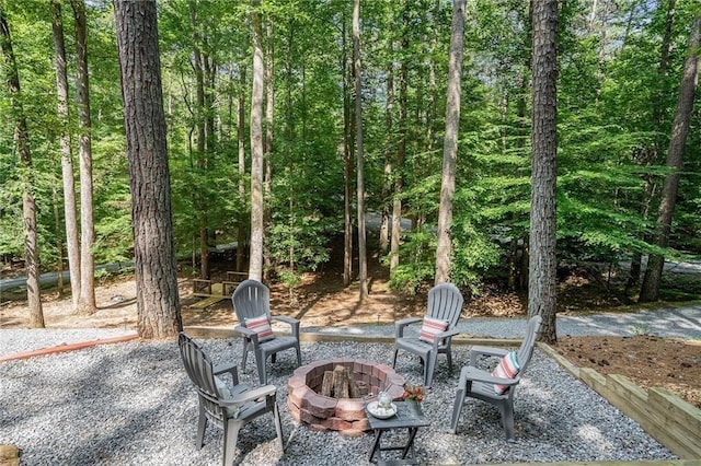 view of patio / terrace featuring a fire pit and a wooded view