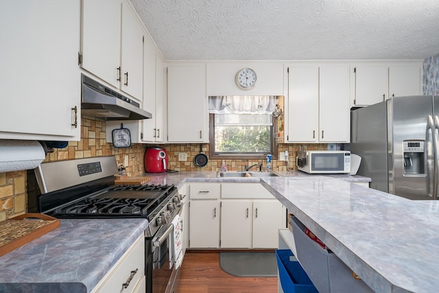 kitchen with stainless steel appliances, white cabinetry, dark wood-type flooring, and sink