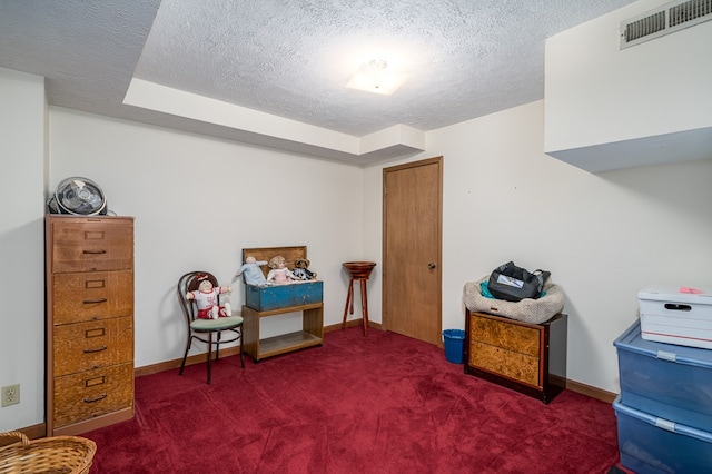 living area with a textured ceiling and dark carpet