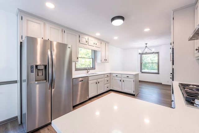 kitchen with stainless steel appliances, white cabinetry, plenty of natural light, and sink