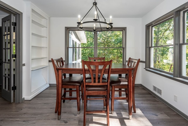 dining space with dark hardwood / wood-style floors and a chandelier