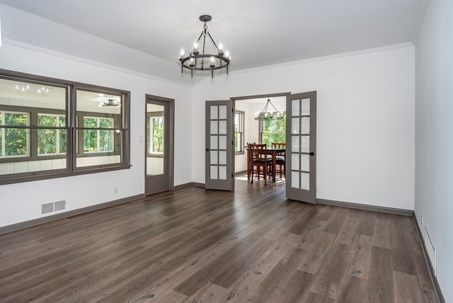 unfurnished room featuring crown molding, french doors, dark hardwood / wood-style floors, and a notable chandelier