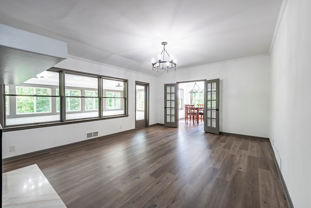 empty room with dark hardwood / wood-style floors, french doors, crown molding, and a chandelier