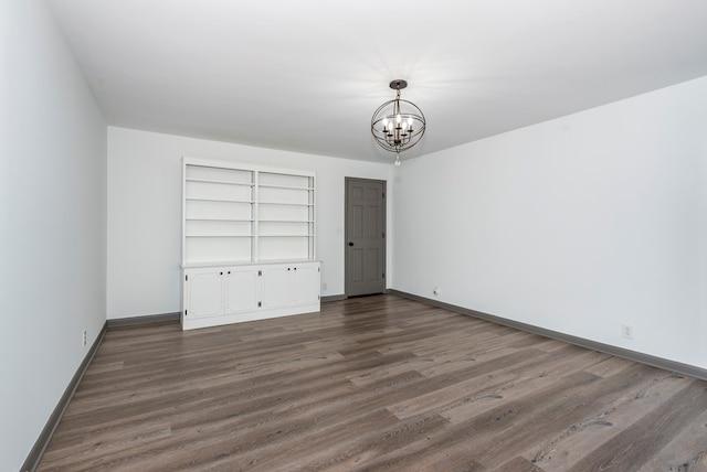 unfurnished bedroom with a chandelier and dark wood-type flooring