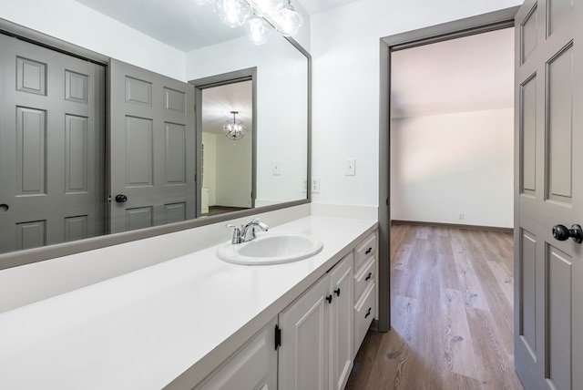 bathroom with vanity, a chandelier, and hardwood / wood-style flooring