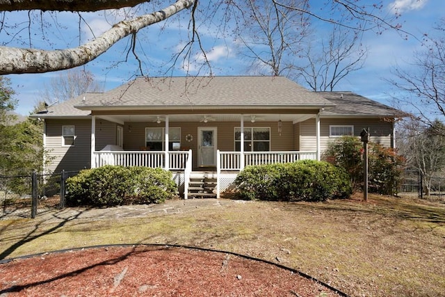 view of front facade featuring a ceiling fan, a gate, fence, and covered porch