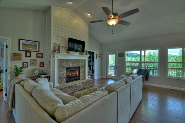 living room featuring high vaulted ceiling, plenty of natural light, a ceiling fan, and a stone fireplace