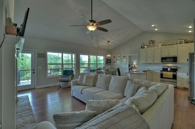 living area with high vaulted ceiling, hardwood / wood-style floors, a ceiling fan, recessed lighting, and baseboards