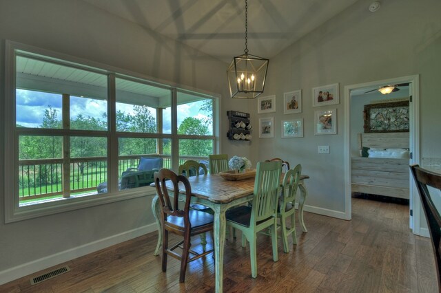 dining space with visible vents, baseboards, wood finished floors, and an inviting chandelier