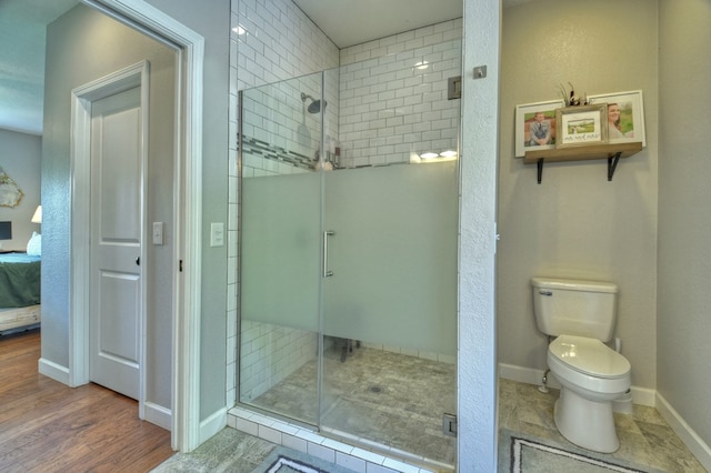 bathroom with baseboards, a stall shower, toilet, and connected bathroom