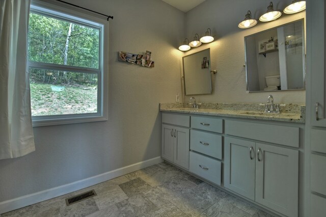 full bath featuring visible vents, a sink, baseboards, and toilet