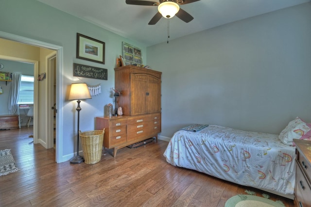 bedroom with baseboards, a ceiling fan, and wood finished floors