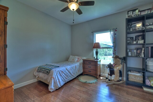 bedroom with baseboards, ceiling fan, and wood finished floors