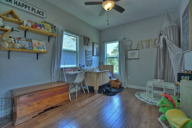 office space featuring baseboards, a ceiling fan, and wood finished floors
