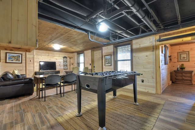 game room with plenty of natural light, wood walls, and wood tiled floor