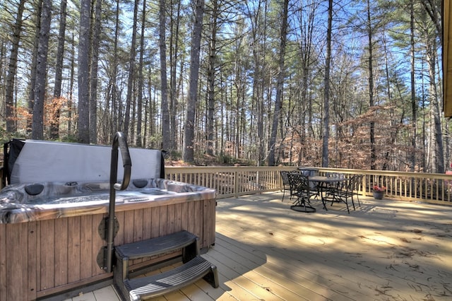 deck featuring outdoor dining space and a hot tub