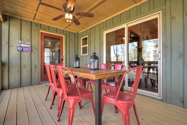 wooden deck featuring outdoor dining space and a ceiling fan