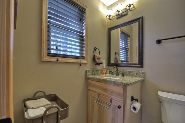 half bathroom with vanity and toilet