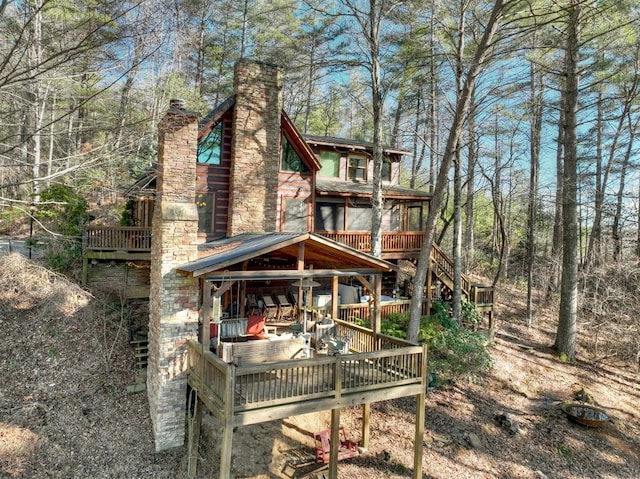 rear view of property with a chimney and a wooden deck