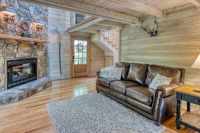 50 Rustic Rdg, Blue Ridge, GA 30513 - living room with wooden walls, wood ceiling with exposed beams, stairway, wood finished floors, and a stone fireplace