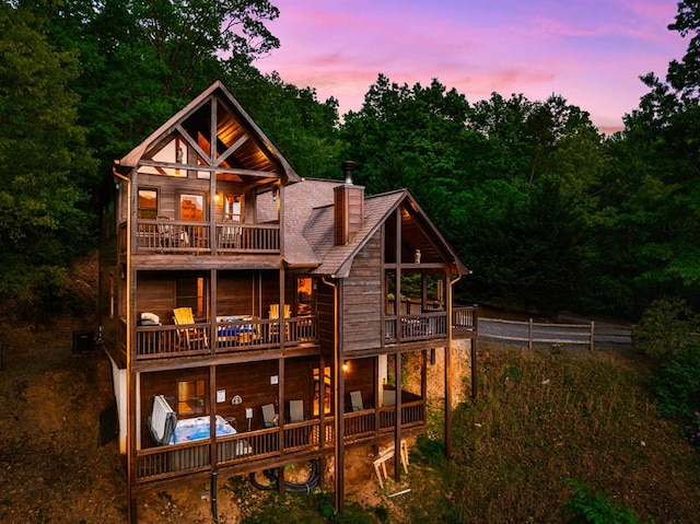 back house at dusk featuring a balcony