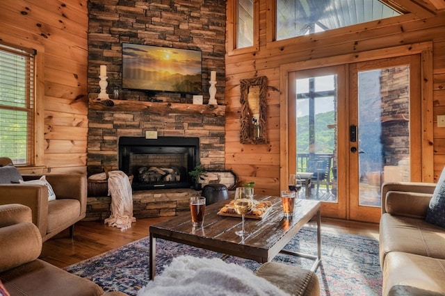 living room with wood-type flooring, french doors, and wood walls