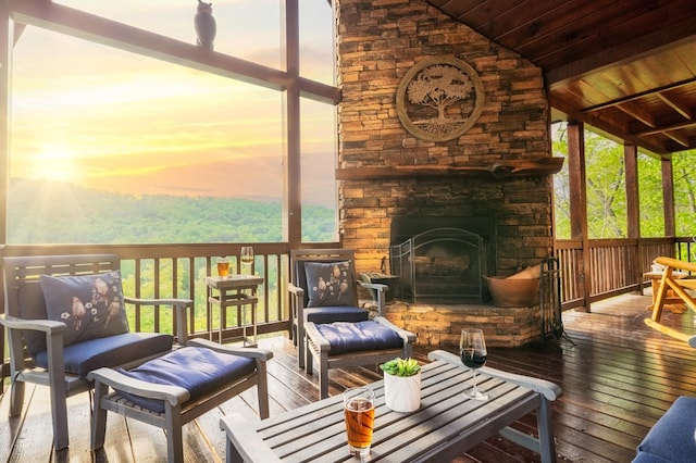 sunroom featuring lofted ceiling, wood ceiling, and an outdoor stone fireplace