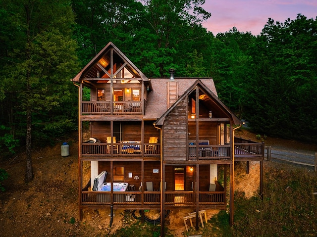 back house at dusk with a balcony