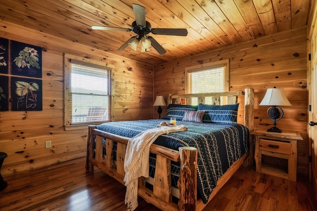 bedroom with dark hardwood / wood-style floors, wooden ceiling, ceiling fan, and wood walls