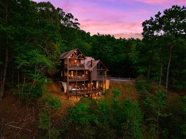 back house at dusk with a balcony