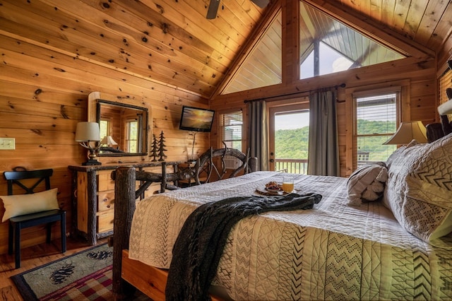 bedroom featuring access to exterior, wooden walls, and lofted ceiling with beams