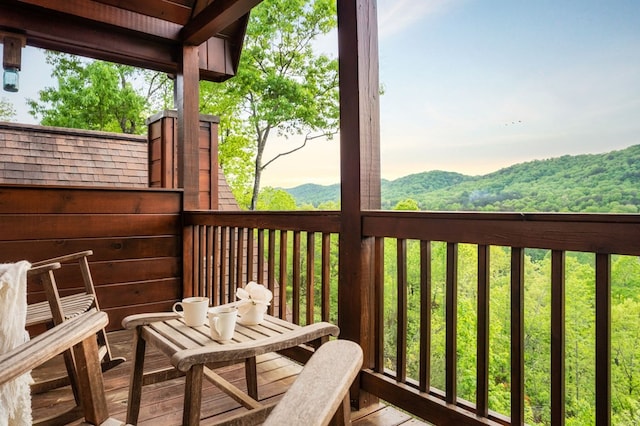 balcony at dusk featuring a mountain view