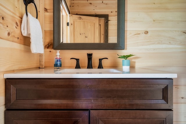 bathroom featuring vanity and wooden walls