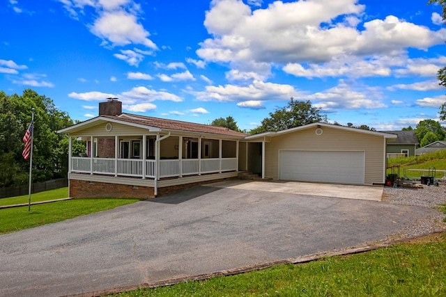 view of front facade featuring covered porch, a chimney, a front yard, aphalt driveway, and an attached garage