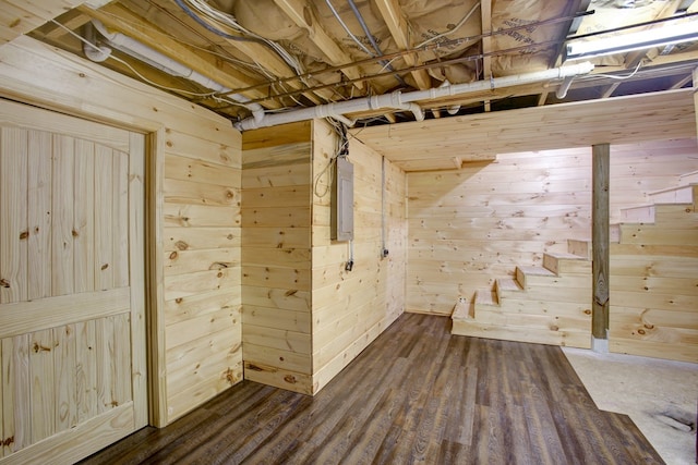 unfinished below grade area with wooden walls and electric panel