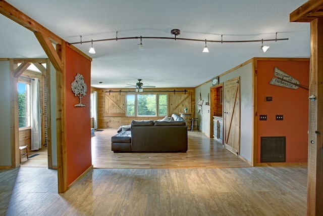 living room with ceiling fan, visible vents, wood finished floors, and rail lighting