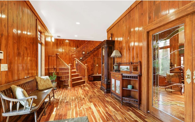 sitting room with wood walls and light hardwood / wood-style flooring