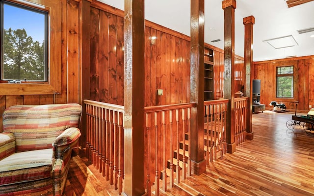 corridor with light hardwood / wood-style flooring and wood walls